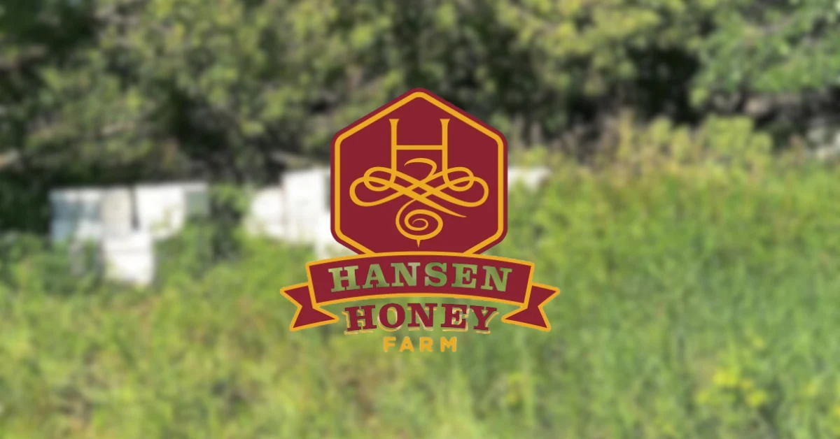 First-party Hansen Honey Farm share image: the red hexagon H crest and Hansen Honey Farm ribbon logo over a blurred photo of white hive boxes in green foliage.