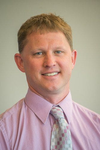 Portrait of Penn State Extension Educator Tom Butzler in a pink shirt and patterned tie, from the Beekeeping 101 course page.